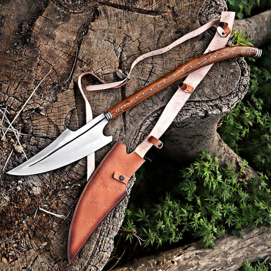 Hand-forged J2 high carbon steel Viking spear with polished wooden handle and leather sheath resting on a wooden tree stump. Norse medieval collector's weapon replica for LARP, cosplay, and unique decor.